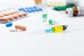 Assorted medical drugs and syringe on white background