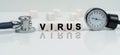 On a reflective white surface lies a stethoscope and cubes with the inscription - VIRUS