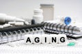 On the table are diaries, medicines and cubes with the inscription - AGING