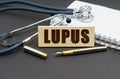 On the table is a notebook, a stethoscope and a sign with the inscription - LUPUS Royalty Free Stock Photo