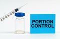 On the table is a syringe, an injection and a blue sign with the inscription - Portion Control Royalty Free Stock Photo