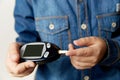 Medicine, diabetes, glycemia, health care and people concept - close up of man checking blood sugar level by glucometer