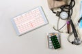 Medicine doctor working the heart report analysis electrocardiogram on digital tablet with a stethoscope