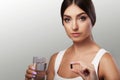 Medicine. Drink water with medicines. A young girl holds a medic Royalty Free Stock Photo