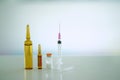 Medicine or drugs in vial and ampules packages and syringe and needle on blur background with copy space Royalty Free Stock Photo