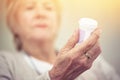 Medicine, hands and woman with bottle of pills for recovery, health and wellness. Closeup, elderly patient and reading