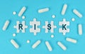 On a blue background, there are pills and puzzles with the inscription - RISK