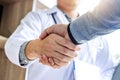 Medicine and health care concept, Professional Male doctor in white coat handshake with patient after successful recommend