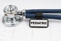 On the cardiogram is a stethoscope and a plate with the inscription - PEDIATRIC