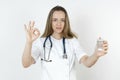 Medicine and health concept. Doctor woman holds pills in her hands, shows gesture - OK Royalty Free Stock Photo