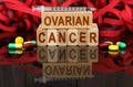 On the surface are visible tablets a syringe wooden dies and their reflections on which it is written - OVARIAN CANCER