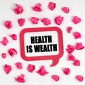 On the table are crumpled blue pieces of paper and a thought plate with the inscription - Health Is Wealth Royalty Free Stock Photo