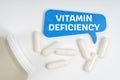 On the table are pills and a blue sign that says - Vitamin deficiency Royalty Free Stock Photo