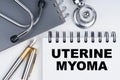 On the table are a stethoscope, a pen and a notebook with the inscription - Uterine myoma
