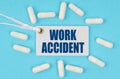 There is a label on the table among the pills that says - WORK ACCIDENT