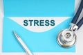 There is a stethoscope on the table, an envelope with paper on which it is written - STRESS Royalty Free Stock Photo