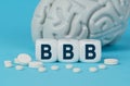 Cubes lie on the table among the pills and imitation of the brain. The text on the dice - BBB