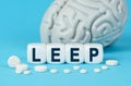 Cubes lie on the table among the pills and imitation of the brain. The text on the dice - LEEP Royalty Free Stock Photo