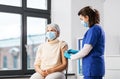 nurse applying medical patch to vaccinated woman