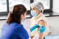 nurse applying medical patch to vaccinated woman