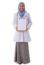 Medicine, healthcare, charity and people concept - smiling muslim female doctor/nurse showing empty blank clipboard sign Royalty Free Stock Photo
