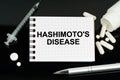 On the black surface are pills, a syringe and a notebook with the inscription - Hashimotos Disease