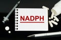 On the black surface are pills, a syringe and a notebook with the inscription - NADPH Royalty Free Stock Photo