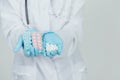 Many small white pill and two blisterpacks of blue and pink pills in the doctor`s hands dressed in the medical Royalty Free Stock Photo