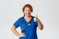 Medicine, healthcare and coronavirus concept. Professional doctor, female medical worker in blue scrubs ensure all good Royalty Free Stock Photo