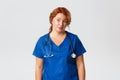 Medicine, healthcare and coronavirus concept. Skeptical and unamused redhead female medical worker, doctor smirk and Royalty Free Stock Photo