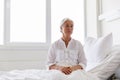 Sad senior woman sitting on bed at hospital ward Royalty Free Stock Photo