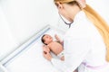 Medicine, healthcare and pediatrics concept - female pediatrician or neuropathist doctor or nurse checking baby patient`s at Royalty Free Stock Photo