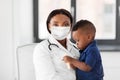 Doctor in mask with baby patient at clinic Royalty Free Stock Photo