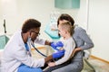 Medicine, healthcare, pediatry and people concept - happy woman with her son and African American doctor with Royalty Free Stock Photo