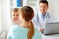 Woman with baby and doctor with laptop at clinic Royalty Free Stock Photo