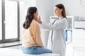 doctor checking lymph nodes of woman at hospital