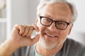 Happy senior man holding white round pill Royalty Free Stock Photo