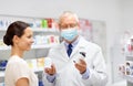 Apothecary and woman with drug at pharmacy Royalty Free Stock Photo