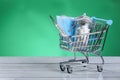 Blue shopping cart with thermometer, medical mask, jar of pills,green background Royalty Free Stock Photo