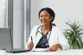 medicine, online service and healthcare concept - happy smiling african american female doctor or nurse with headset and Royalty Free Stock Photo