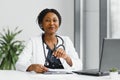 medicine, online service and healthcare concept - happy smiling african american female doctor or nurse with headset and Royalty Free Stock Photo