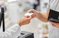 Close up of hand giving bank card to pharmacist