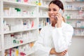 Smiling young female pharmacist talking on the phone Royalty Free Stock Photo