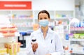 Female apothecary in mask with drug at pharmacy Royalty Free Stock Photo