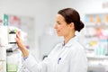 Happy female apothecary with drug at pharmacy Royalty Free Stock Photo