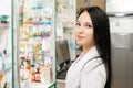 Medicine, pharmacy and optics. Portrait of a woman doctor or pharmacist in a white coat, looking with a smile. In the background a Royalty Free Stock Photo