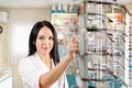 Medicine, pharmacy and optics. Portrait of a woman doctor or pharmacist in a white coat and pulling glasses from the window.