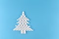 Medicine pills shape of christmas tree on blue background. Concept Christmas and new year