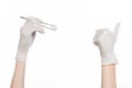 Medicine and Surgery theme: doctor's hand in a white glove holding tweezers with swab isolated on white background in studio Royalty Free Stock Photo