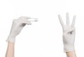 Medicine and Surgery theme: doctor's hand in a white glove holding tweezers with swab isolated on white background in studio Royalty Free Stock Photo